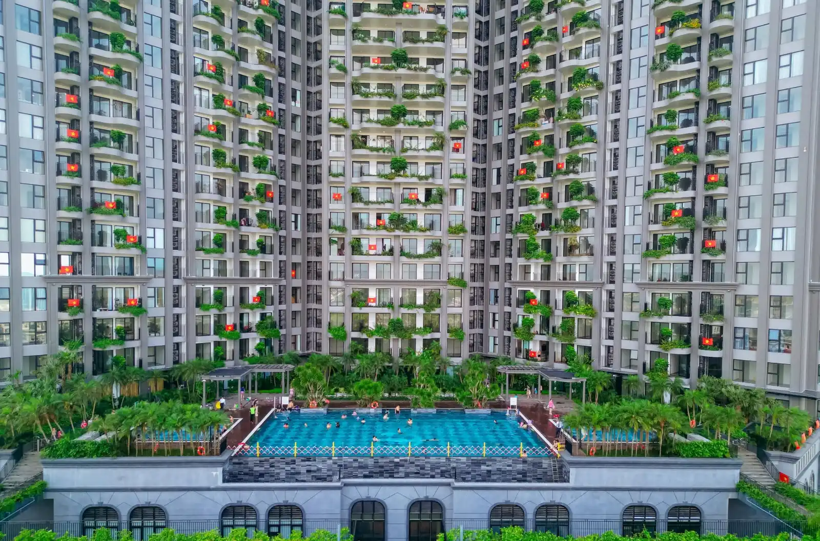 Hình ảnh góc chính diện tòa nhà căn hộ cao cấp và bể bơi ngoài trời xanh mát tại khu nghỉ dưỡng Ecopark MDPStay